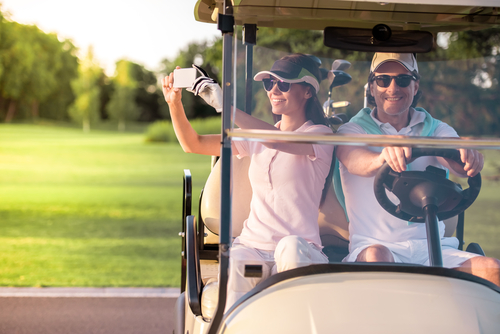 beautiful-couple-smiling-while-driving-golf-cart